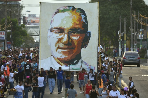 People carry a picture of the late Archbishop Romero during a march ahead of the 34th anniversary of his assassination in San Salvador