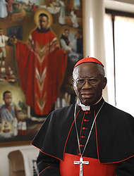 Nigerian Cardinal Francis Arinze, retired prefect of the Congregation for Divine Worship and the Sacraments, is pictured in front of an image of Blessed Cyprian Michael Tansi in his residence at the Vatican Feb. 12. Cardinal Arinze, who personally heard Pope Benedict XVI's resignation, said "I have no doubt about his wisdom....He doesn't rush, he is not rash, he is gentle but he is also clearheaded and firm. So it could not have been an idea he got the day before." (CNS photo/Paul Haring) (Feb. 12, 2013) See BENEDICT-ARINZE Feb. 12, 2013.