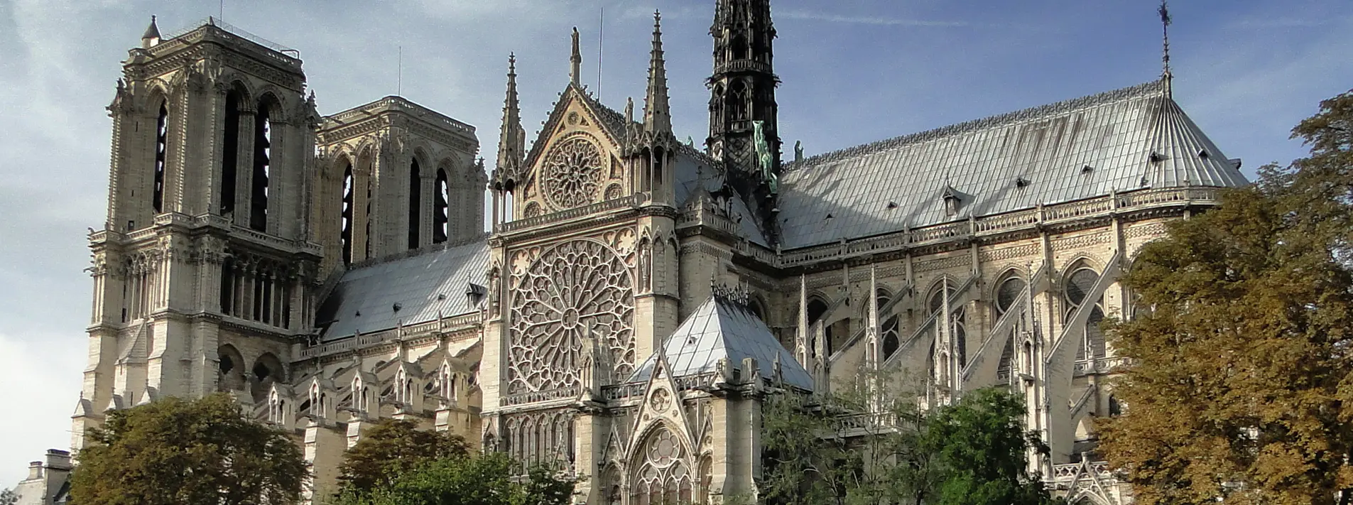 A panoramic hero view of Notre-Dame Cathedral along the Seine in Paris