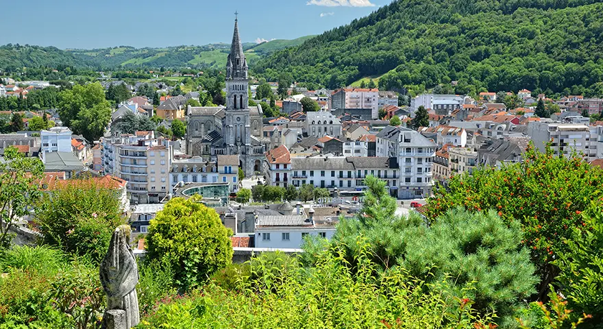 The town of Lourdes in the foothills of the Pyrenees, with the Église Paroissiale du Sacré-Cœur on the skyline, France