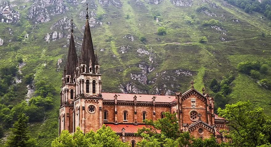 Basilica of Santa María la Real de Covadonga with twin spires rising above the green Asturian mountainside, Spain