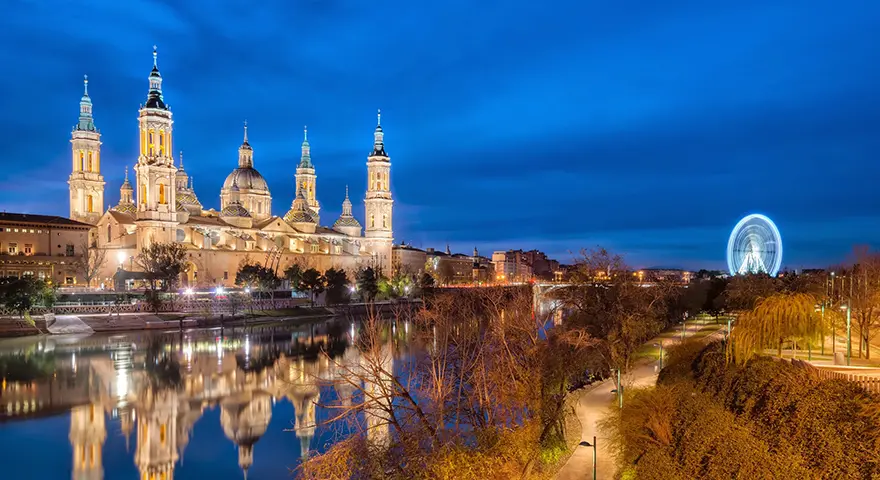 Basilica of Our Lady of the Pillar with its four towers and tiled domes seen across the Ebro River, Zaragoza