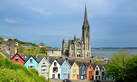 The colorful houses of Cobh with St. Colman's Cathedral rising behind them