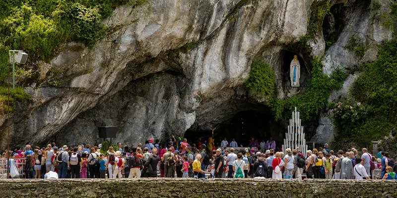 Pilgrims gather in prayer before the Grotto of Massabielle