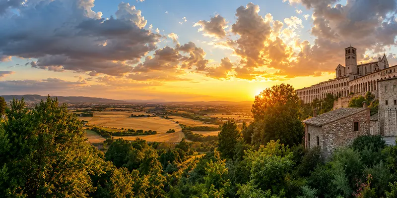 The hilltop town of Assisi with the Basilica of Saint Francis at golden hour.