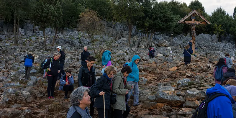 A parish pilgrimage group gathered in prayer together at a holy site