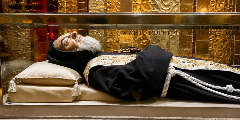 The tomb of Saint Padre Pio behind glass in the lower church at San Giovanni Rotondo, Italy.