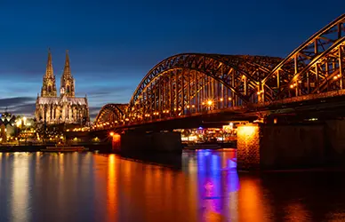 Cologne Cathedral and the Hohenzollern Bridge over the Rhine at night — Germany pilgrimage
