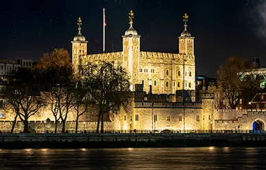 The Tower of London floodlit at night, where Sts. Thomas More and John Fisher were held before their execution